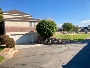 View of side of home with a yard and a garage