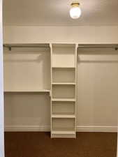 Walk in closet featuring carpet floors his and hers