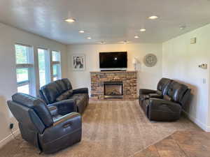 Living room featuring tile patterned floors, a textured ceiling, and a fireplace