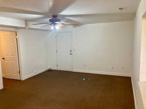 Carpeted empty room featuring a textured ceiling and ceiling fan