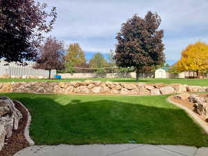 View of yard with a storage shed and volleyball court