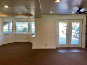 Entryway with french doors, carpet floors, and a textured ceiling