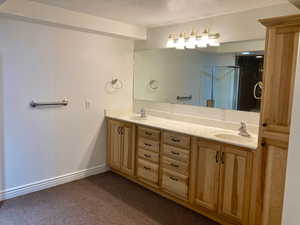 Bathroom featuring vanity, a textured ceiling, and walk in shower