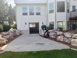 View of side of home with cooling unit and a balcony