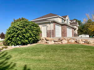 View of property exterior with a garage and a lawn