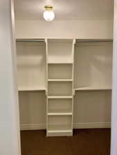 Walk in closet featuring carpet flooring his and hers