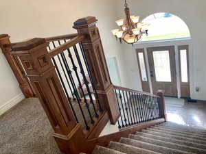 Stairs featuring an inviting chandelier