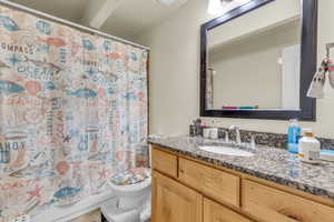 Bathroom with toilet, a textured ceiling, and vanity