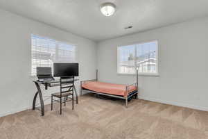 Bedroom with a textured ceiling and carpet