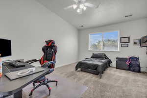 Carpeted bedroom with vaulted ceiling and ceiling fan