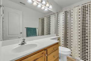 Bathroom featuring vanity, toilet, tile patterned floors, and walk in shower