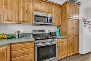 Kitchen featuring stainless steel appliances and dark hardwood / wood-style flooring