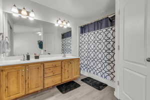 Bathroom with vanity, curtained shower, and hardwood / wood-style floors