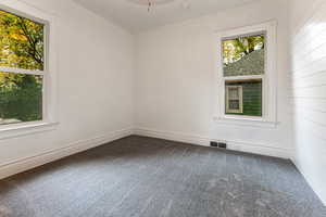 Carpeted empty room with wooden walls