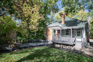 View of back of house with a deck, a pergola, and a back lawn