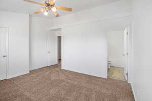 Carpeted empty room with ceiling fan