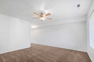 Spare room with a healthy amount of sunlight, carpet, and ceiling fan