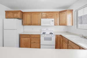 Kitchen with white appliances and sink