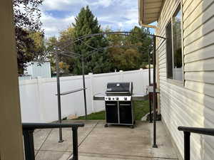 View of patio with a grill and arch with cover that can be put up when needed