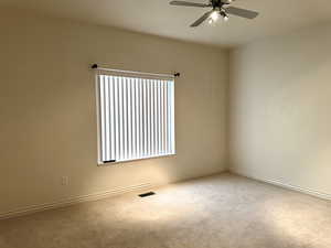 Front bedroom featuring ceiling fan, a healthy amount of sunlight, and carpet