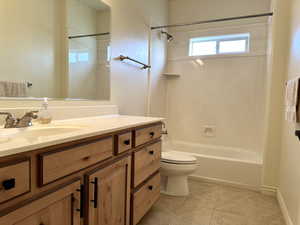 Full bathroom with vanity, toilet, tile patterned floors, beautiful cabinets and shower / tub combination