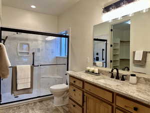 Primary Bathroom featuring updated vanity, toilet, and a shower with shower door