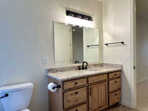 Primary bathroom featuring updated modern lighting and granite countertops