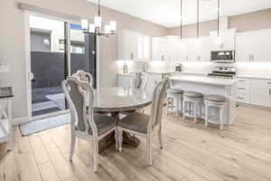 Dining room featuring an inviting chandelier, sink, and light wood-type flooring