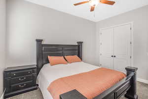 Carpeted bedroom with a closet and ceiling fan