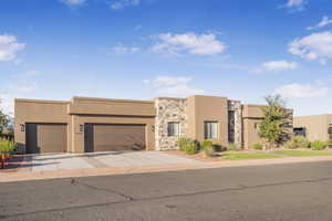 Pueblo revival-style home featuring a garage