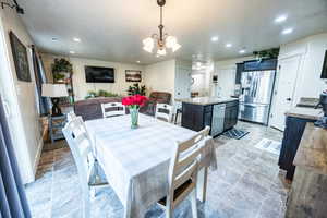 Dining room featuring a textured ceiling, a notable chandelier, and recessed lighting