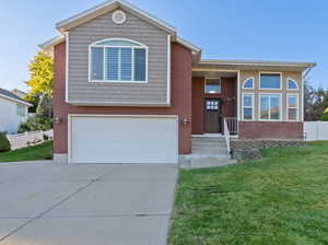 View of front of property featuring a front yard and a garage