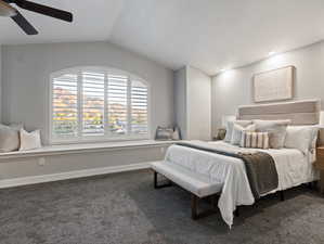 Bedroom with lofted ceiling, dark carpet, and ceiling fan