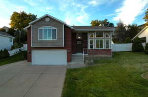 View of front of home featuring a front yard and a garage