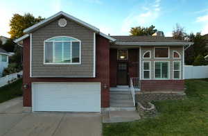 View of front of home with a front yard and a garage