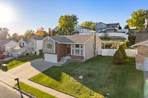 View of front of property featuring a garage and a front lawn