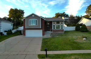 View of front facade with a garage and a front lawn