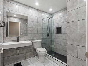 Bathroom with toilet, tile walls, and an enclosed shower