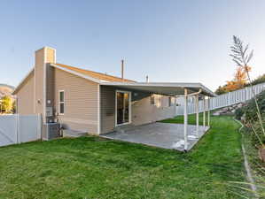 Rear view of house featuring a patio area, a yard, and central AC unit