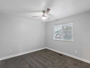 Carpeted empty room featuring ceiling fan