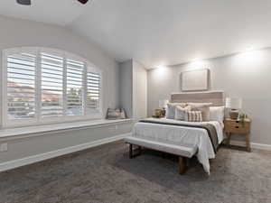 Main Bedroom with ceiling fan, vaulted ceiling, and dark colored carpet