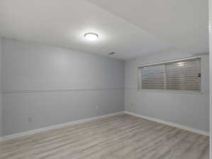 Spare room with light hardwood / wood-style floors and a textured ceiling