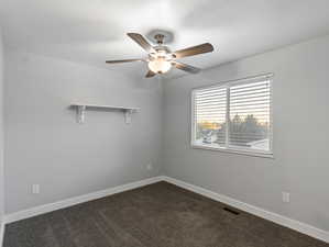 Carpeted empty room with ceiling fan