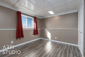 Spare room featuring wood-type flooring and coffered ceiling