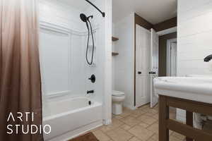 Bathroom featuring shower / bath combination with curtain and toilet