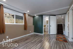 Unfurnished bedroom with hardwood / wood-style flooring, ensuite bathroom, and sink