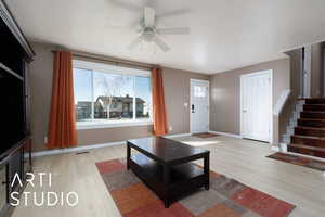 Living room featuring a wealth of natural light, light hardwood / wood-style floors, and ceiling fan