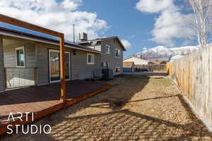 Rear view of house with cooling unit and a deck with mountain view