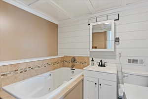 Bathroom with vanity, toilet, and a tub to relax in