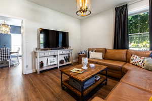 Living room featuring a notable chandelier and hardwood / wood-style flooring